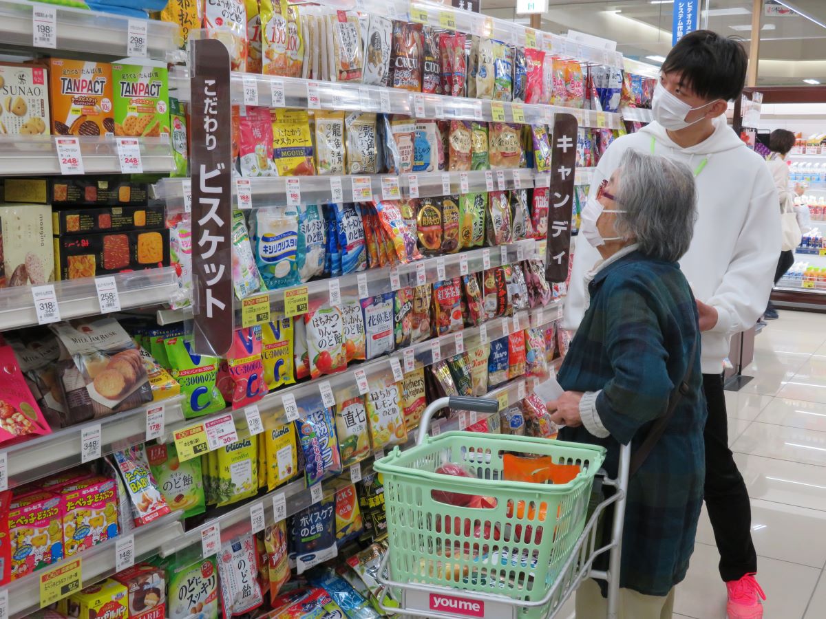 Young man assists elderly woman with shopping