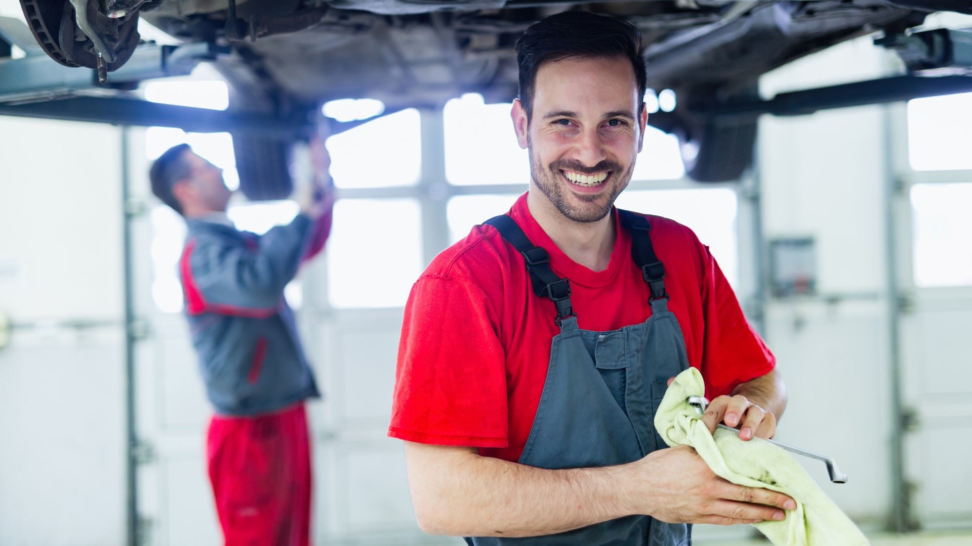 Two men in a workshop working on a car